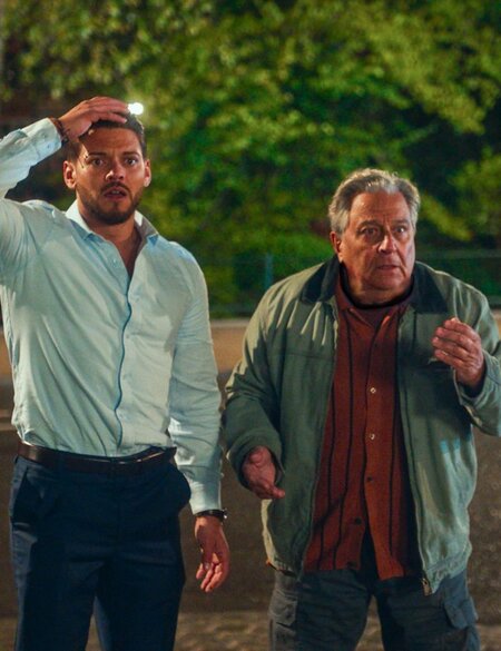 Die Schauspieler Christian Clavier und Rayane Bensetti stehen in dem Kinofilm "Ab durch die Mitte – Mit Vollgas durch Paris" auf einer Straße mit einem entsetzten Gesichtsausdruck | © Happy Entertainment