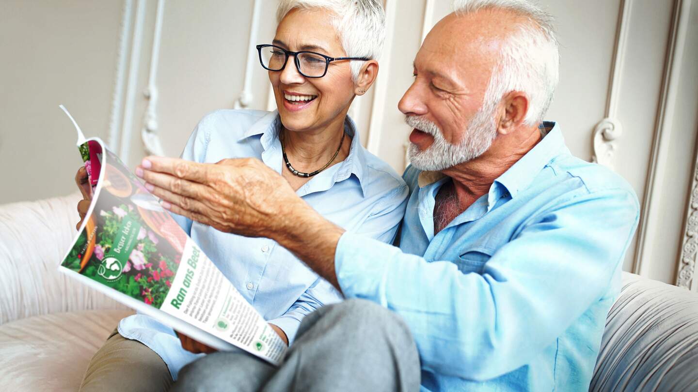 Eine Frau und ein Mann im Best Age lesen fröhlich lachend im Magazin prisma | © PRISMA-Verlag GmbH/gilaxia