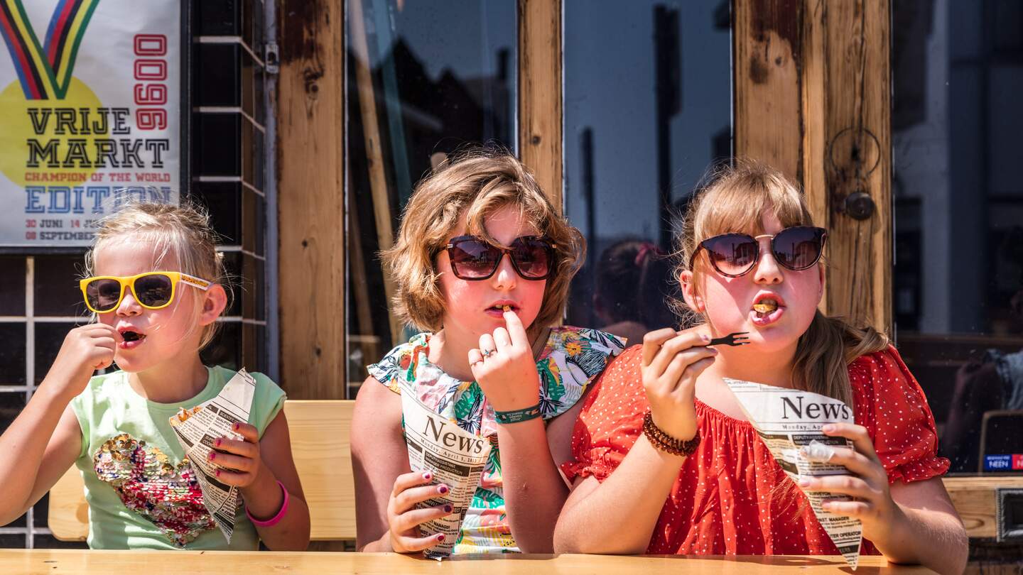 Kinder essen auf einer Urlaubsreise in Belgien belgischen Pommes | © Piet De Kersgieter