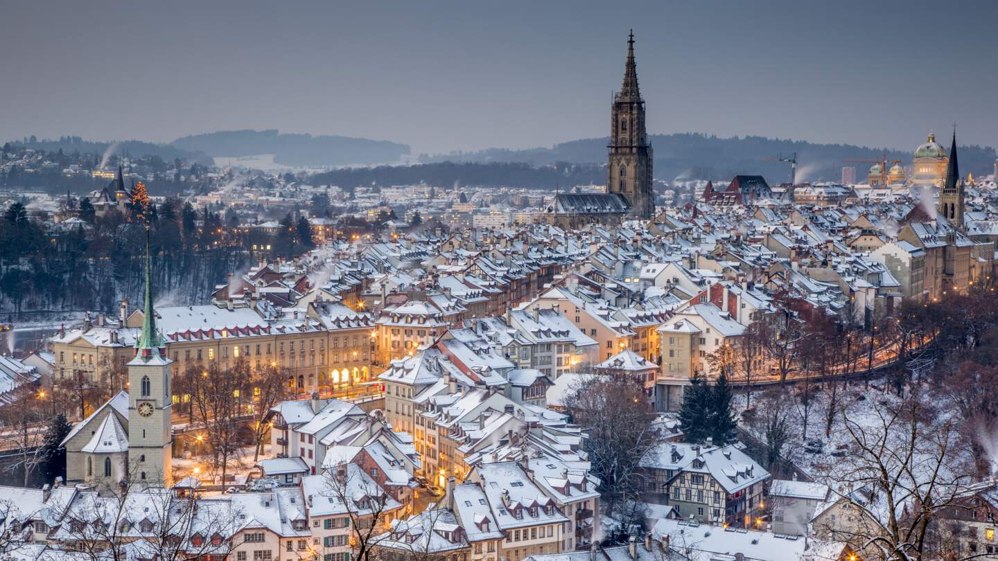 Die winterliche, schneebedeckte Altstadt von Bern, festlich beleuchtet zur Weihnachtszeit, aus der Vogelperspektive. | © Jan Geerk