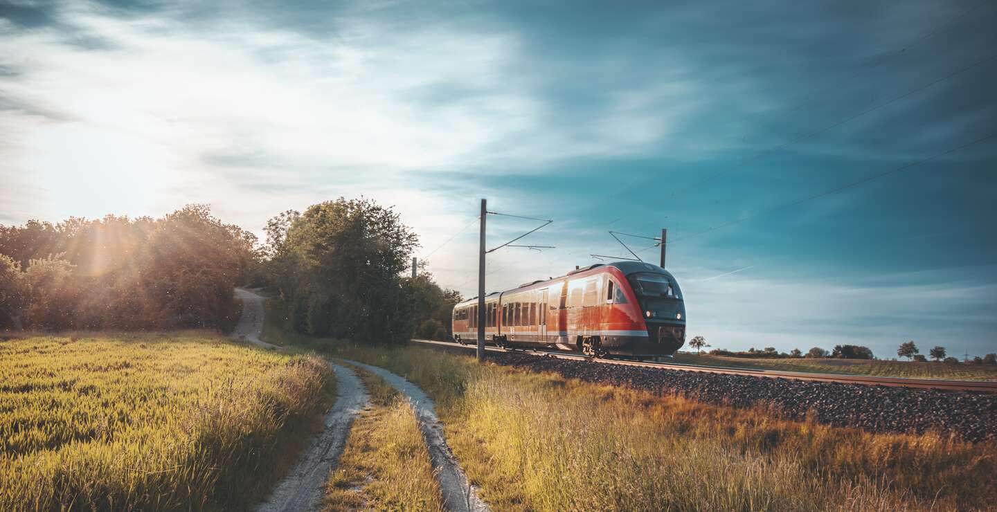 Roter DB Zug fährt durch die Natur | © GettyImages.com/Say-Cheese
