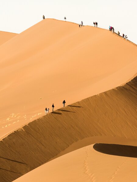 Tourist klettert auf eine Sanddüne in Sossusvlei bei einer Fahrt mit dem African Explorer.  | © © Gettyimages.com/2630ben