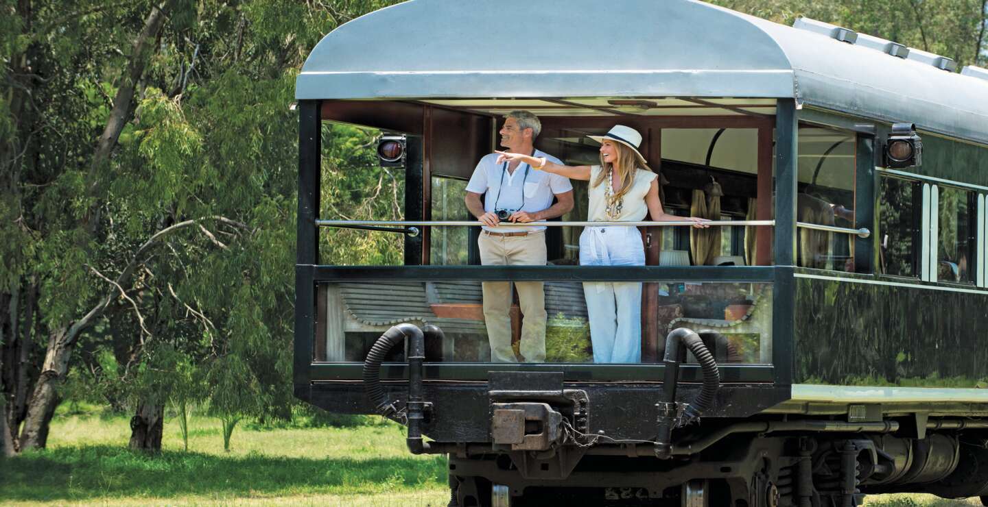 Ein schoenes Paar geniesst die Natur vom Balkon des Rovos Rail  | © DOOKPHOTO