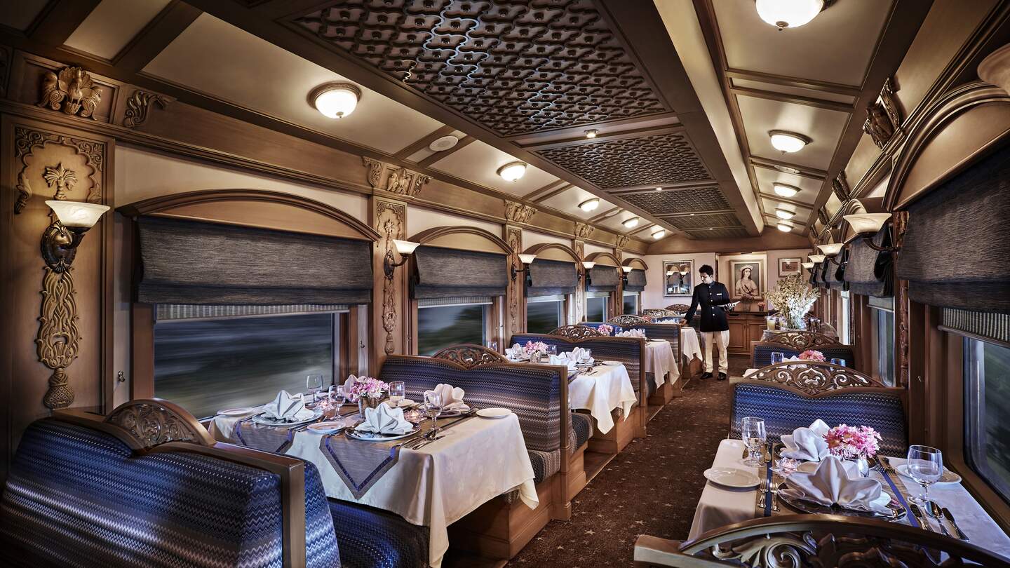 Ein Mitarbeiter deckt die Tische im Restaurant-Waggon im Deccan Odyssey in Indien  | © Deccan Odyssey