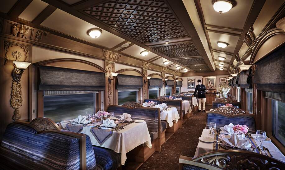 Ein Mitarbeiter deckt die Tische im Restaurant-Waggon im Deccan Odyssey in Indien 