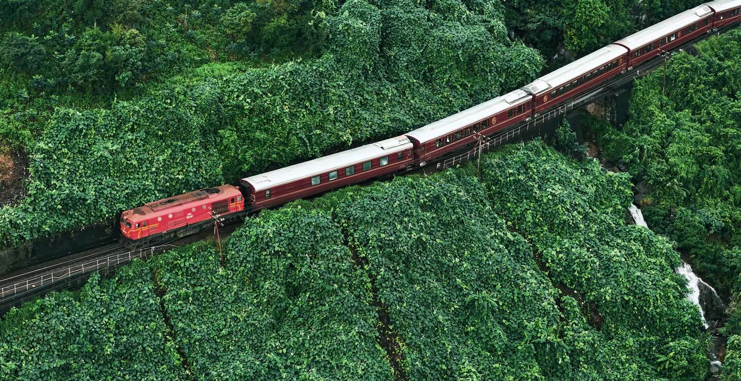 Luftaufnahme des Zuges Sjourney, der in Vietnam durch grünen Dschungel fährt | © Sjourney