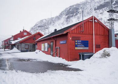 rotes Gebäude des Bahnhof Myrdal im Schnee | © GettyImages.com/Stavrida