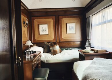 Twin-Abteil im Royal Scotsman mit zwei Betten und einem Schreibtisch | © belmond.com/Ludovic Balay