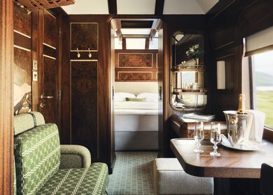 Innenraum einer luxuriösen Grand Suite mit Sofa, Tisch und einem Bett im Hintergrund | © belmond.com/Ludovic Balay
