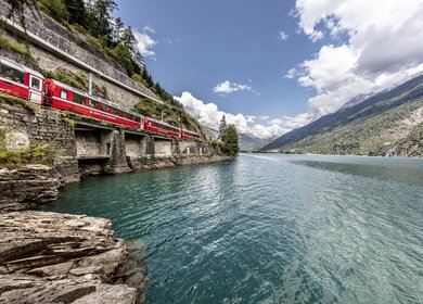 Im Panoramawagen des Bernina Expresses am Lago di Poschiavo in der Schweiz | © © Rhätische Bahn / Andrea Badrutt