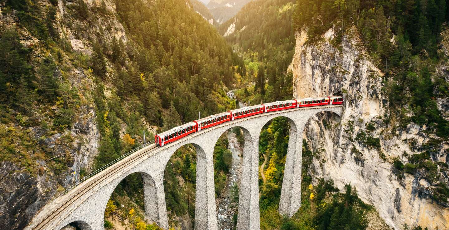 Im Panoramawagen des Bernina Expresses auf dem Landwasserviadukt im Herbst in der Schweiz | © Gettyimages.com/nikada