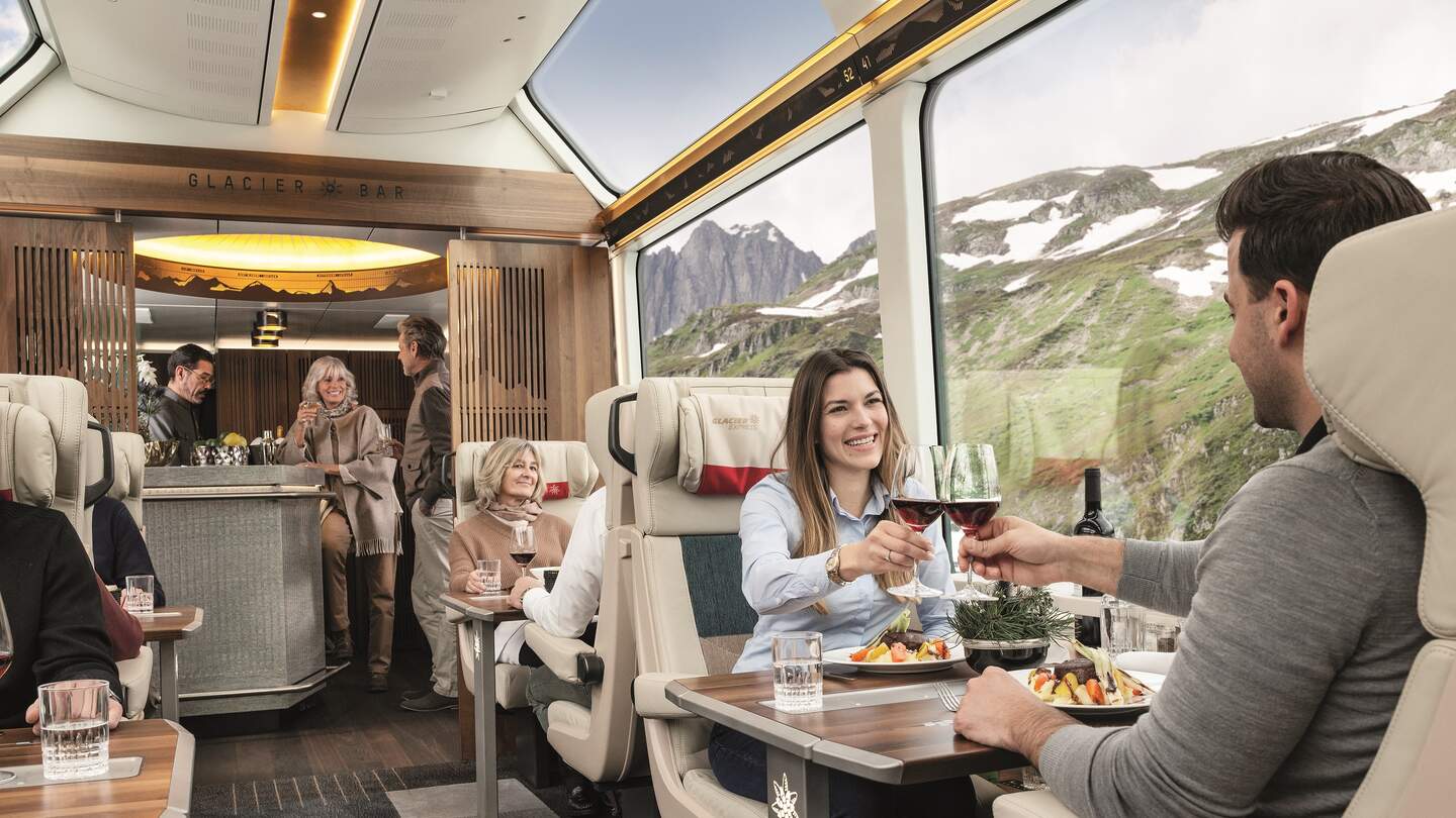 Ein Paar sitzt in der Excellence Class des Glacier Express bei einer Zugfahrt durch die Schweiz  | © Glacier Express AG/Peter Hummel