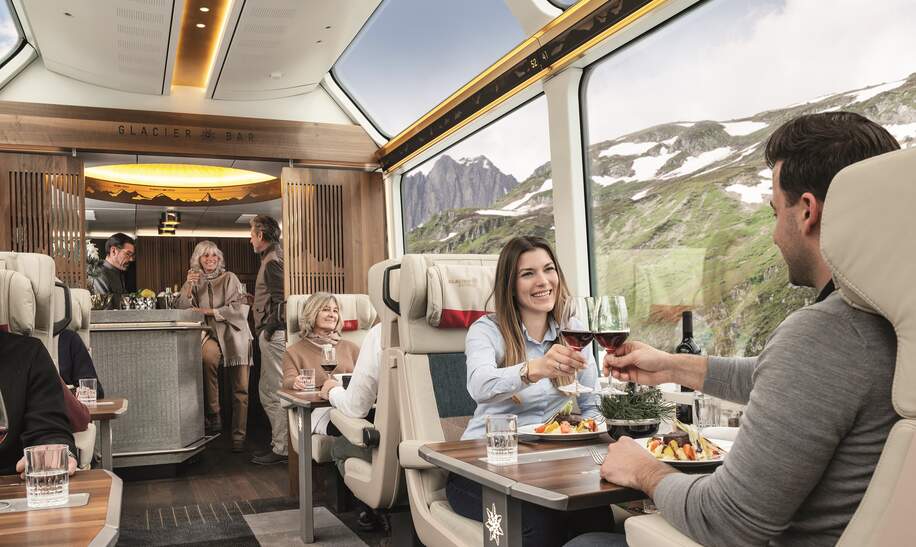 Ein Paar sitzt in der Excellence Class des Glacier Express bei einer Zugfahrt durch die Schweiz  | © Glacier Express AG/Peter Hummel