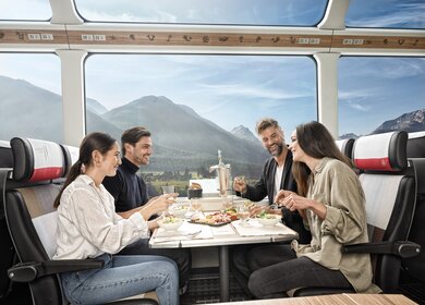 Zwei Paare sitzten im Speisewagen 2. Klasse mit Panoramafenstern | © Glacier Express AG/Stefan Schlimpf