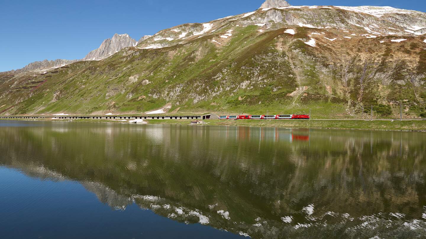 Der Glacier Express fährt vorbei am Oberalpsee in der Schweiz | © Glacier Express AG/Stefan Schlimpf