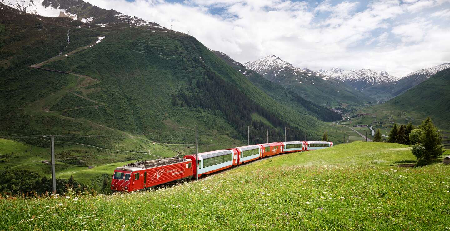 Der Glacier Express fährt über den Oberalppass in den Schweizer Alpen im Sommer | © Glacier Express AG/Stefan Schlimpf