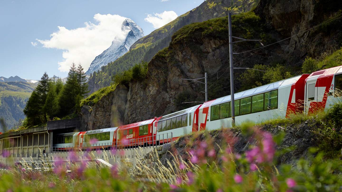 Der Glacier Express fährt durch Zermatt in der Schweiz im Frühling | © Glacier Express AG/Stefan Schlimpf