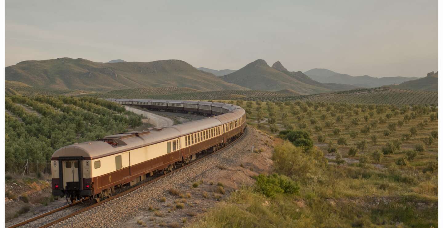 Der El Tren al Andalus auf den Schienen in einer grünen Steppenlandschaft in Andalusien. | © © Renfe