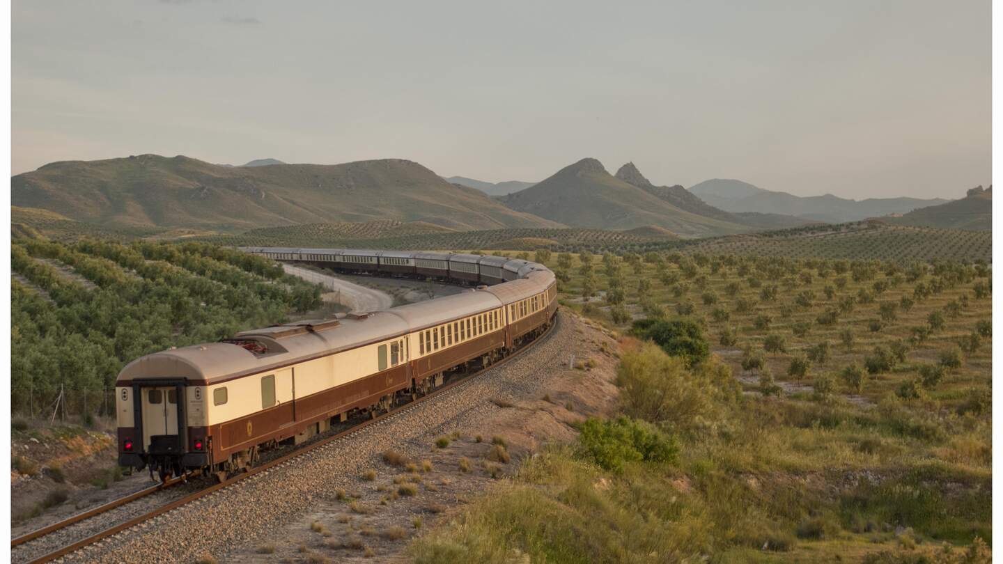 Der El Tren al Andalus auf den Schienen in einer grünen Steppenlandschaft in Andalusien. | ©  1999 Adobe Systems Incoporated/Renfe