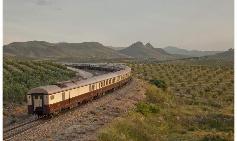 Der El Tren al Andalus auf den Schienen in einer grünen Steppenlandschaft in Andalusien. | © © Renfe