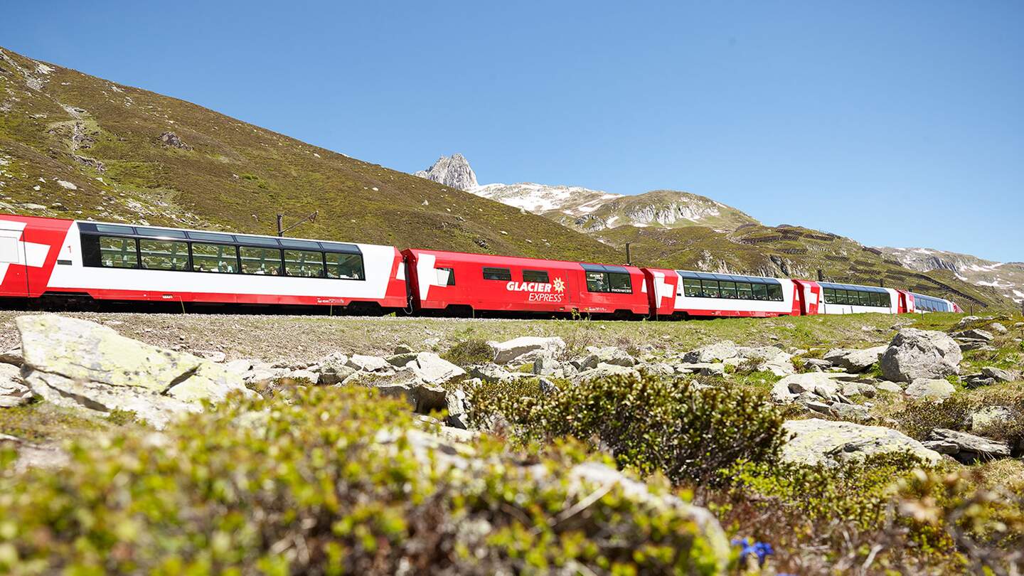 Der Glacier Express faehrt ueber den Oberalppass in den Schweizer Alpen im Fruehling | © Glacier Express AG/Stefan Schlumpf