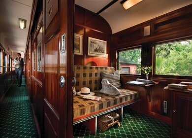 Ein Mitarbeiter im Gang ist auf dem Weg zur Rovos Rail Pullmann Suite mit einem Einzelbett | © Rovos Rail Tours