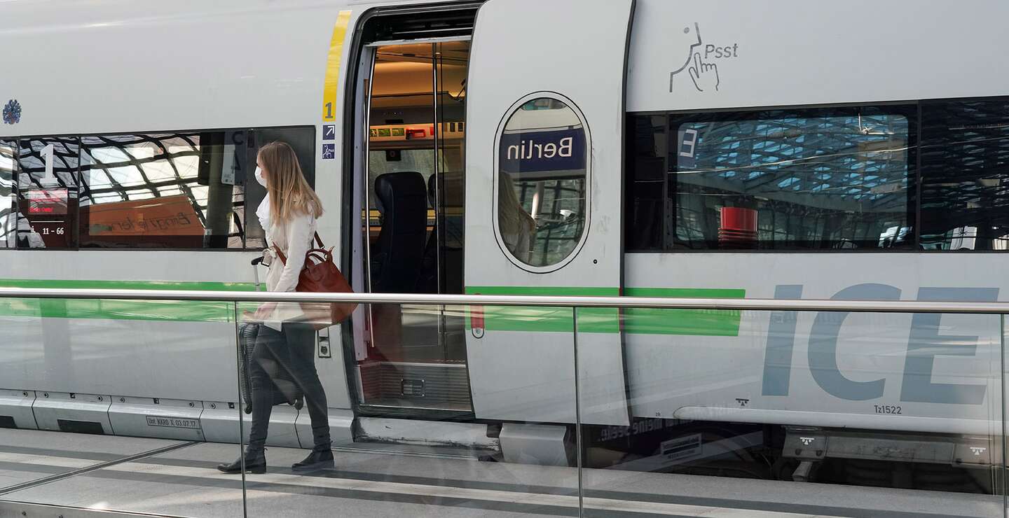 Eine Frau steigt aus einem ICE-Zug aus. Sie traegt eine Tasche und scheint sich auf dem Bahnsteig umzusehen, waehrend sie den Zug verlaesst. | © Deutsche Bahn AG/Volker Emersleben
