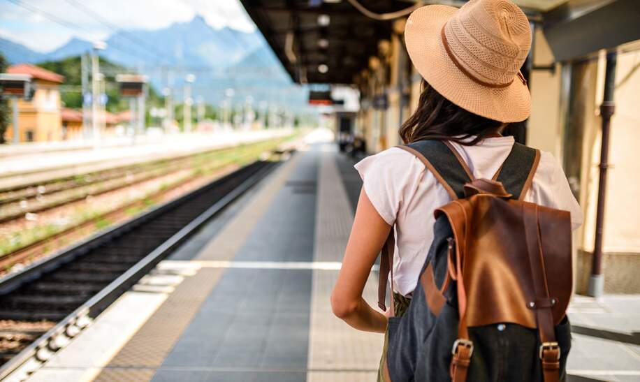 frau mit rucksack am bahngleis im sommer | © Gettyimages.com/MStudioImages