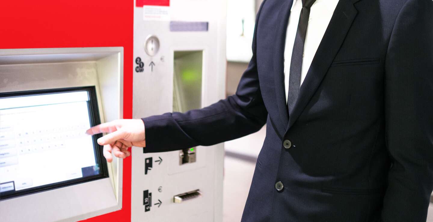 Reisender bedient ein Display und kauft ein Bahnticket am Fahrkartenautomaten | © Gettyimages.com/franckreporter