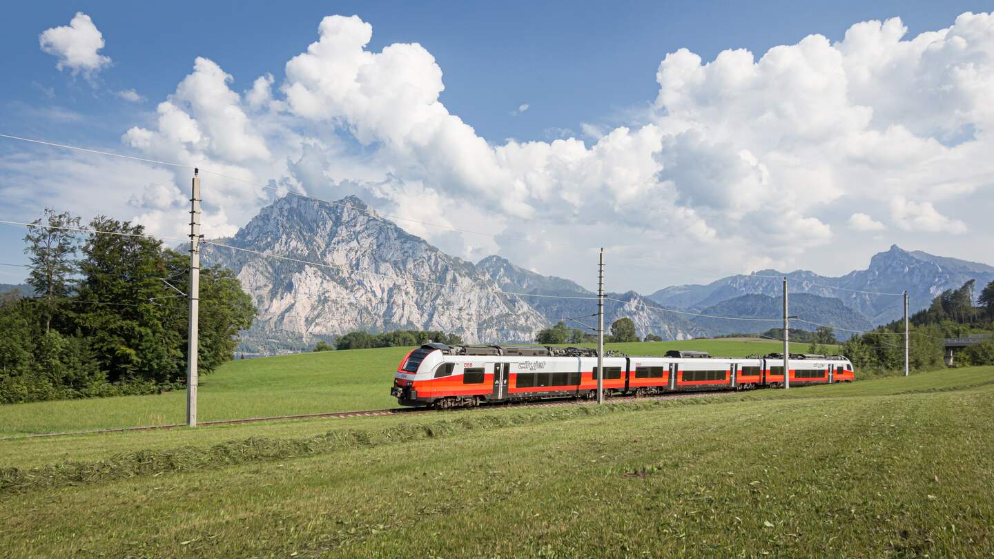 ÖBB Desiro ML Cityjet faehrt ueber eine Wiese mit Bergen im Hintergrund | © ÖBB/Kriechbaum