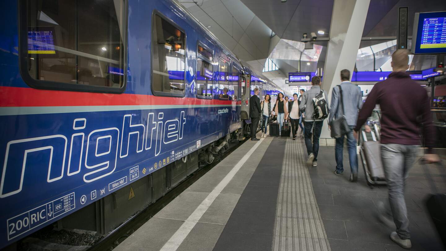 Blick auf einen Wagon des ÖBB Nightjets der neuen Generation am Bahnhof mit vorbeilaufenden Fahrgaesten  | © ÖBB/Harald Eisenberger