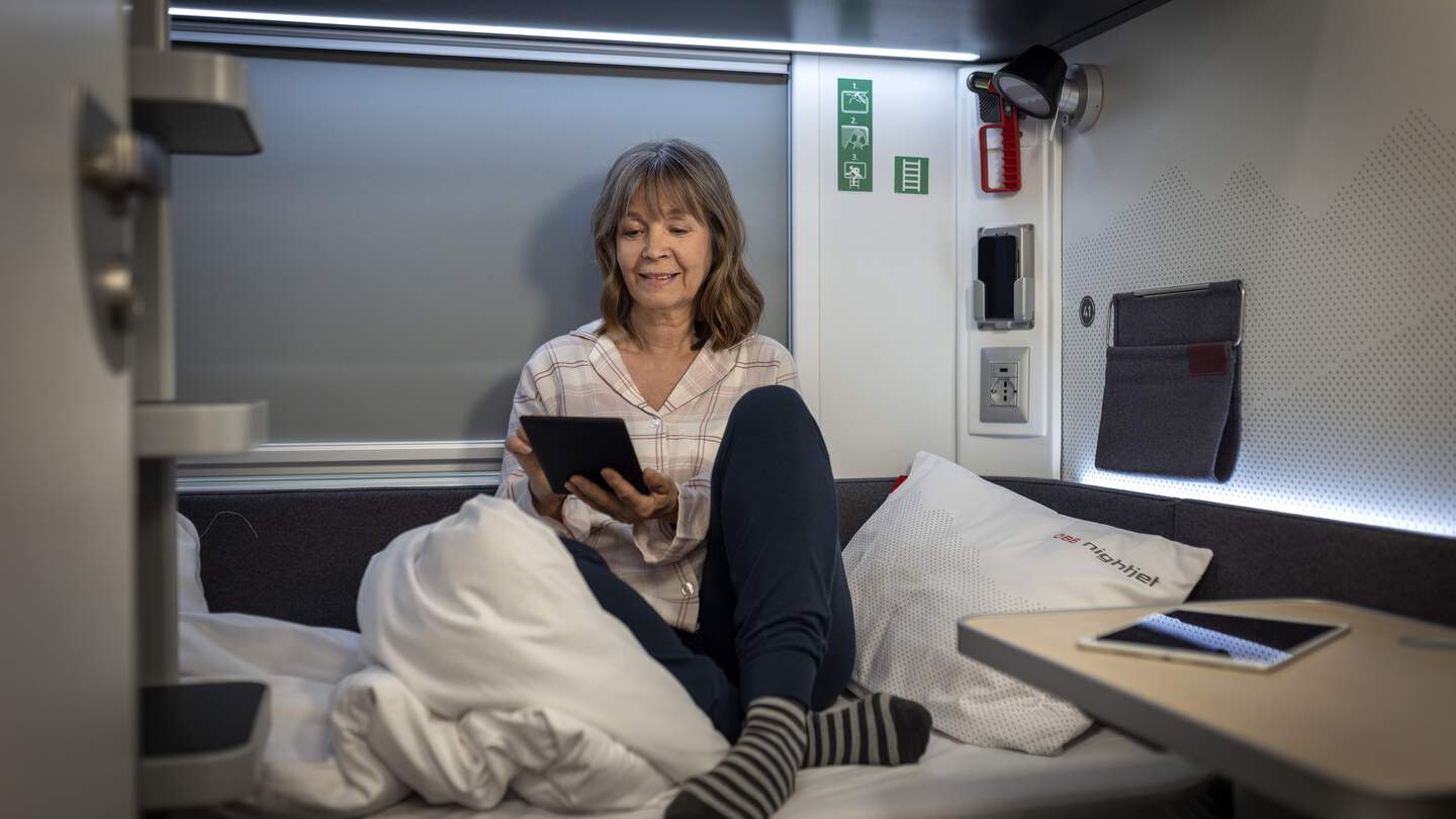 Eine Frau sitzt auf dem Bett der Kategorie comfort im Schlafwagen des ÖBB Nightjets der neuen Generation | © ÖBB/Harald Eisenberger
