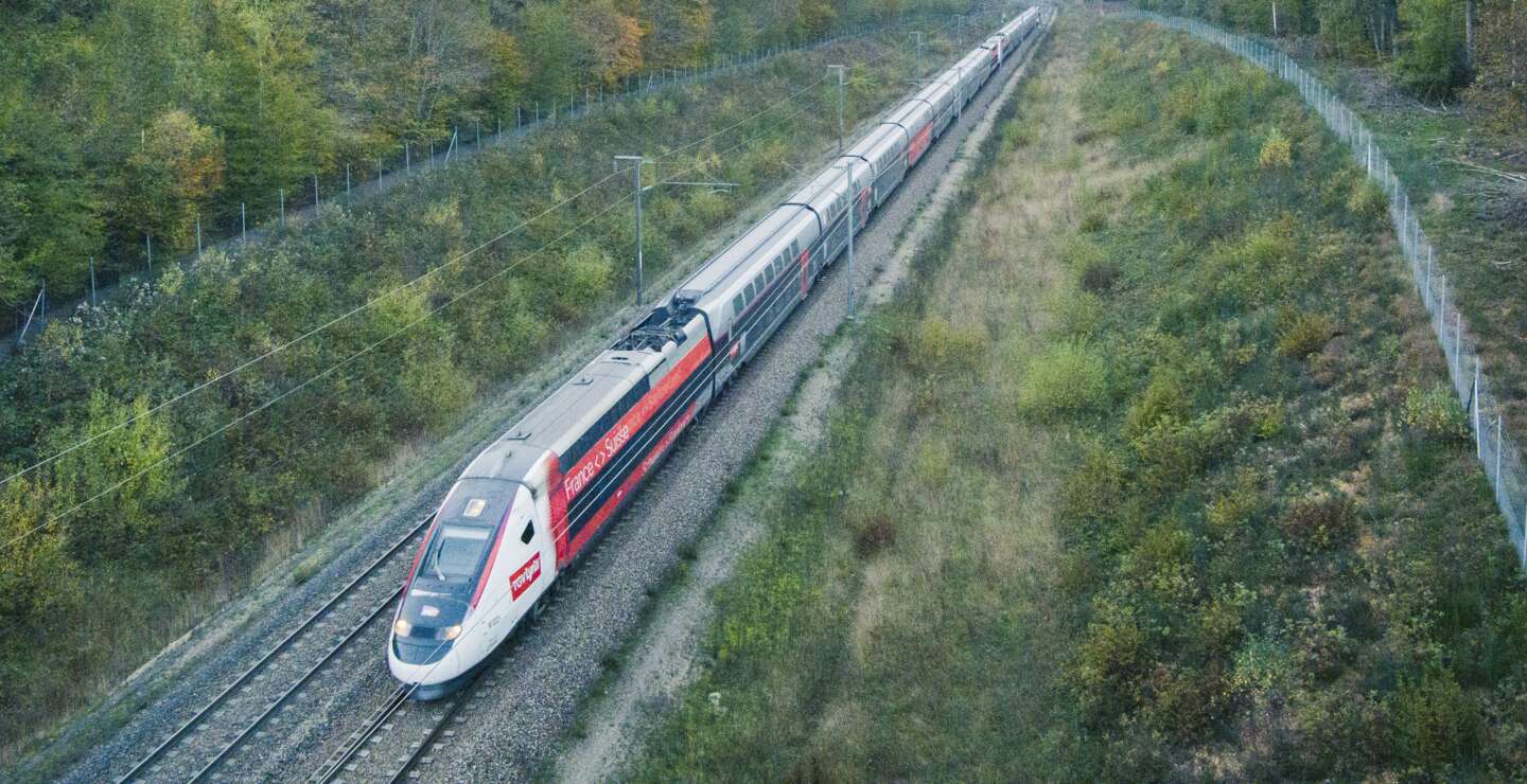 TGV Lyria der SNCF fährt durch eine grüne Landschaft zwischen Frankreich und der Schweiz – komfortable und umweltfreundliche Zugreise | © Olivier Foulon / Groupe SNCF