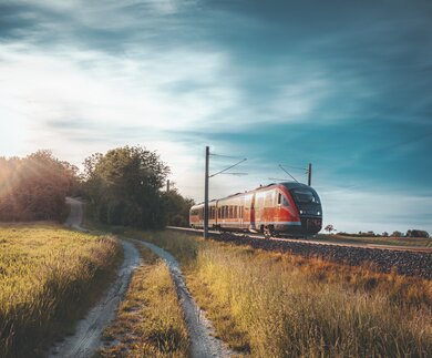 Roter DB Zug fährt durch die Natur | © GettyImages.com/Say-Cheese