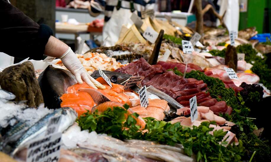 Der Stand eines Fischhändlers in einer Markthalle | © Gettyimages.com/whitemay