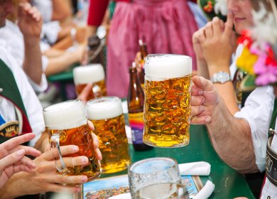 Menschen stossen mit Bier an auf dem Oktoberrfest | © Gettyimages.com/Nikada