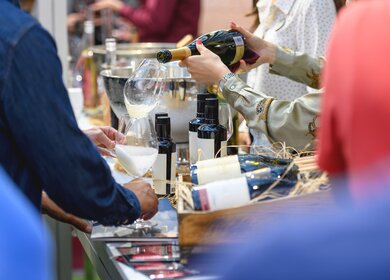 Weisswein wird fuer die Weinverkostung ausgeschenkt | © Gettyimages.com/webphotographeer