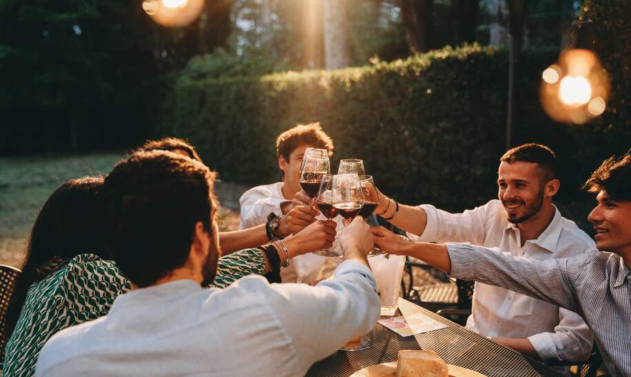 Freunde stossen beim Abendessen gemeinsam an | © Gettyimages.com/filippobacci