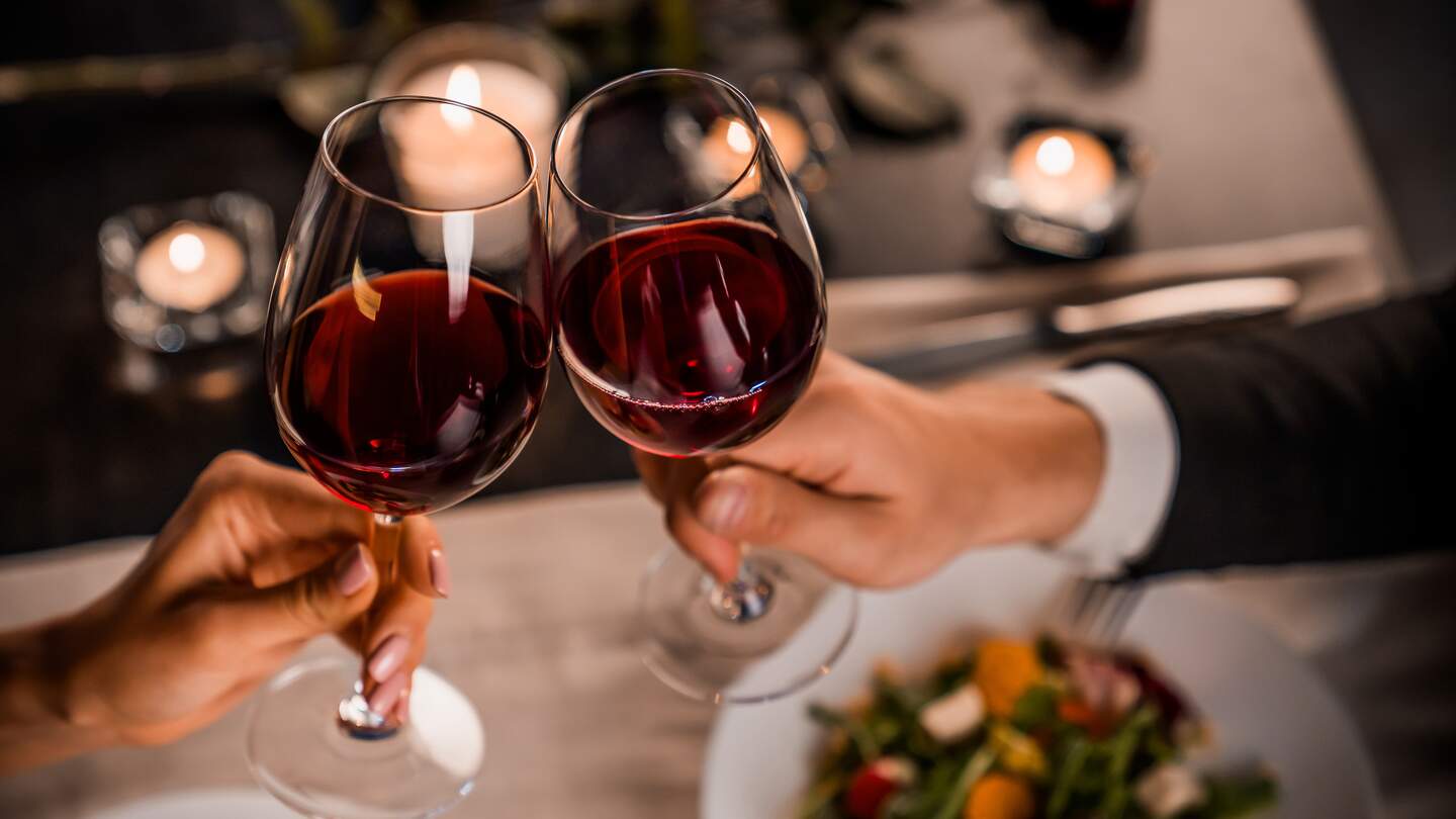 Paar stößt mit Rotwein beim Essen an | © Gettyimages.com/Inside Creative House