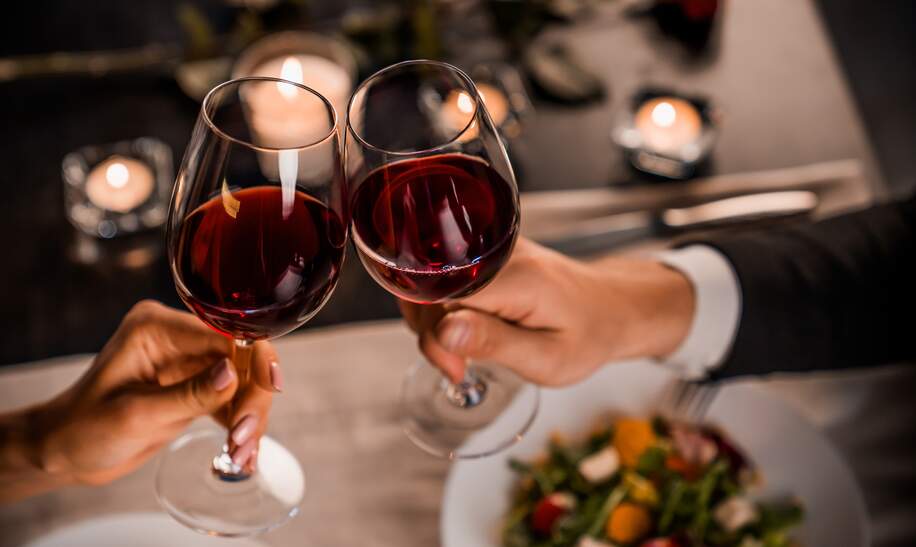 Paar stößt mit Rotwein beim Essen an | © Gettyimages.com/Inside Creative House