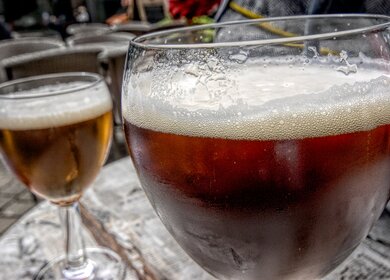 Belgisches Himbeerbier in einem Glas vor einem Straßencafé in Brüssel. Die Belgier sind vor allem für ihre Vielfalt an Bieren und Fruchtbieren bekannt. | © Gettyimages.com/Alphotographic
