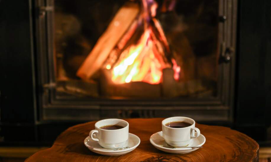 Zwei Kaffeetassen vor dem lodernden Kamin | © Gettyimages.com/Burak Sür