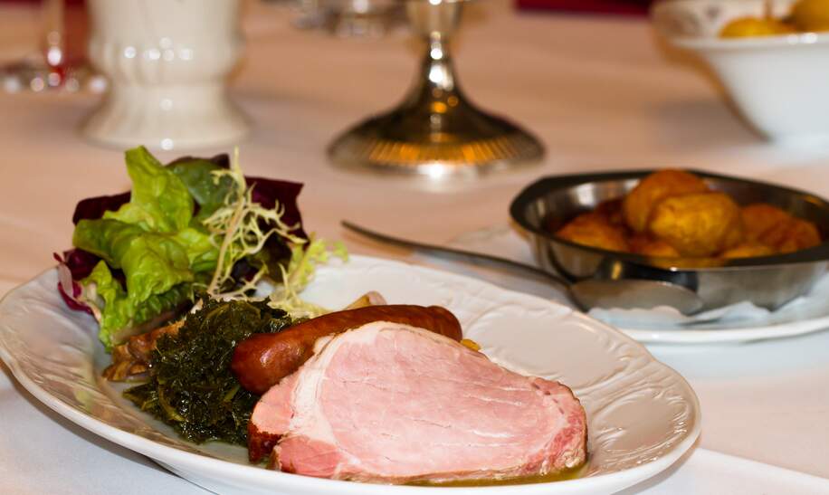 Gedeckter Tisch mit Gruenkohl und geraeuchertem Fleisch | © Gettyimages.com/MaboHH