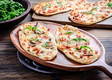 Franzoesischer Flammkuchen mit Frischkaese, Speck und Zwiebeln. Flammkuchen aus dem Elsass | © Gettyimages.com/brebca