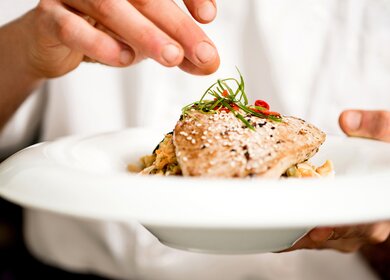 Der Koch verleiht der Thunfisch-Vorspeise den letzten Schliff | © Gettyimages.com/stockyimages