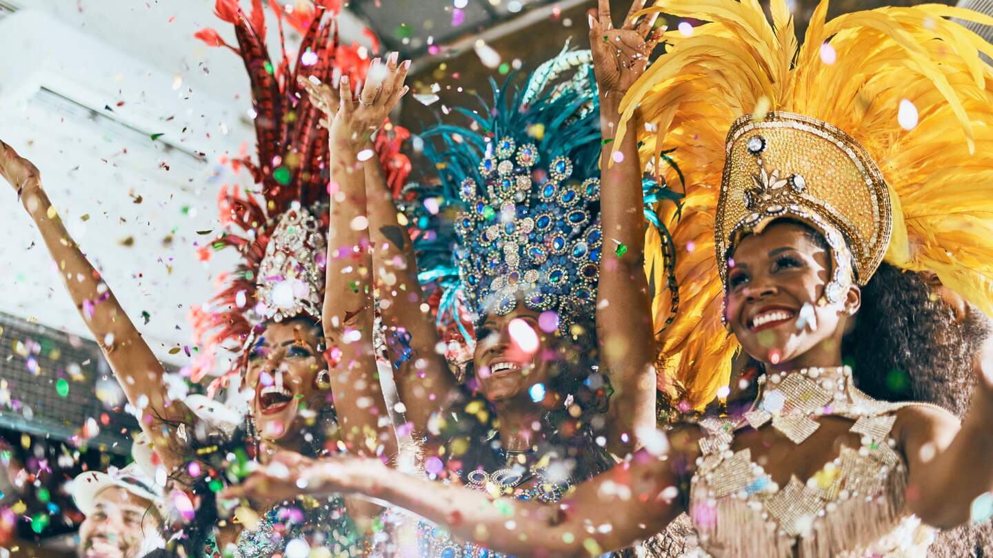 Aufnahme von schönen Sambataenzern, die mit ihrer Band in einem Karneval auftreten | © Gettyimages.com/peoplesimages