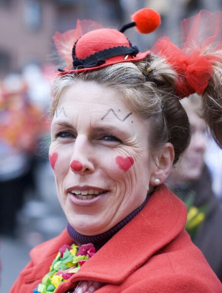 Frau, die gekleidet ist wie ein Clown, auf Straße während des Karnevals | © Gettyimages.com/code6d