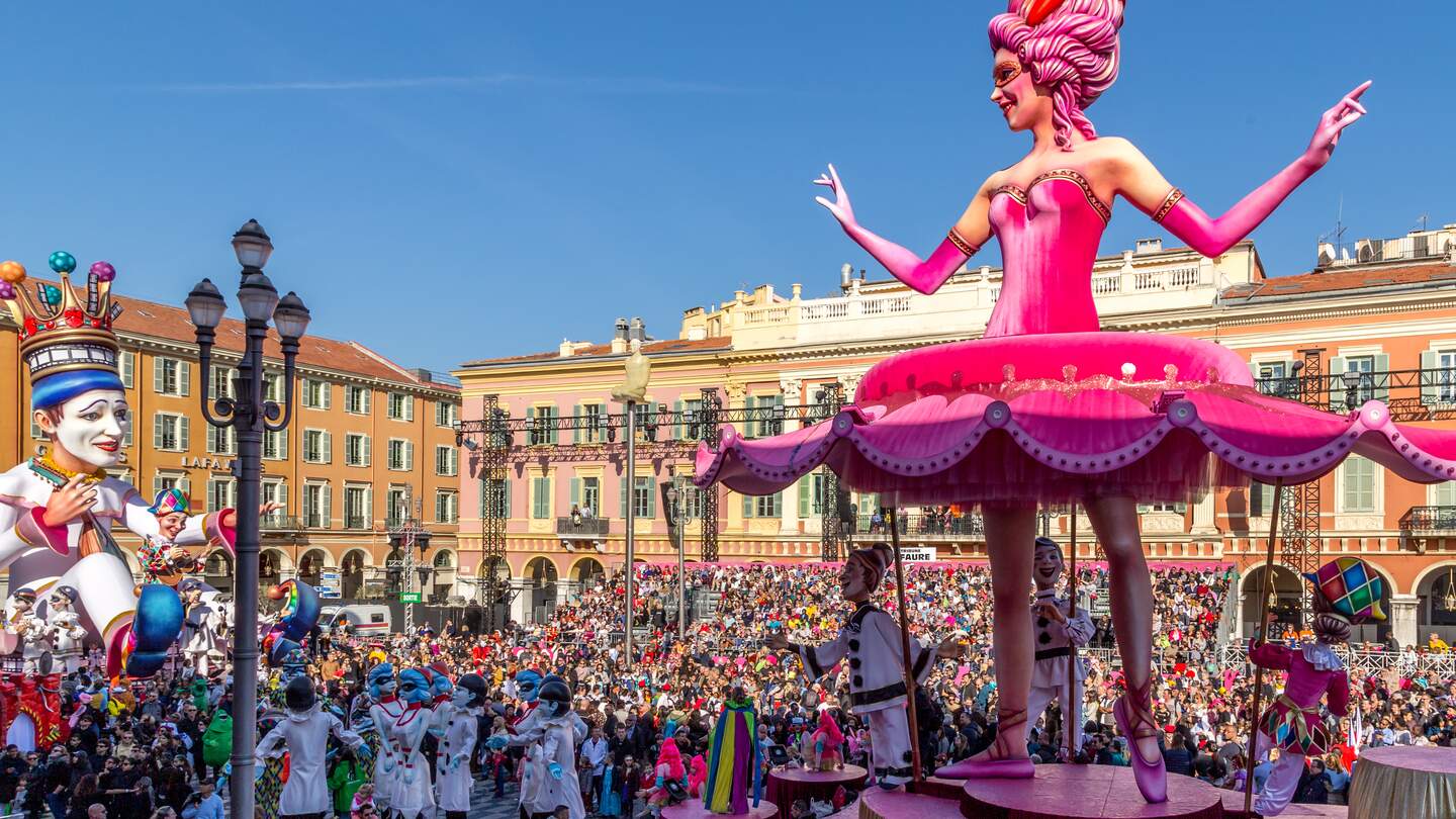 Carnaval de Nice mit dem Thema Koenig des Kinos - Tanzende Ballerina-Wagen blickt mit Hunderten von Menschen im Publikum auf den Koenig des Karnevals zurueck | © Gettyimages.com/Michelle Silke