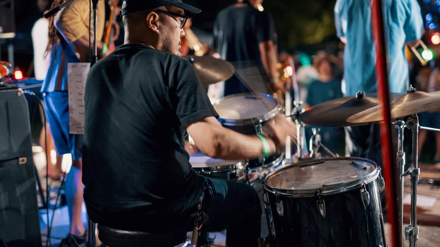 Rückansicht eines Schlagzeugers bei einem festival im Freien | © Gettyimages.com/tdub303