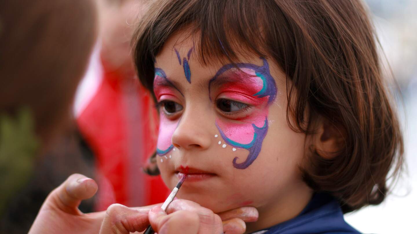 Kleines Maedchen bekommt einen Schmetterling ins Gesicht gemalt | © Gettyimages.com/belgium